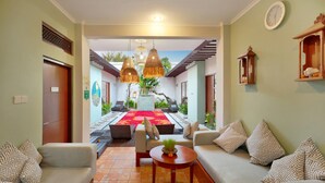 A hotel lobby with a central seating area, a red carpet, and hanging wicker lamps. - The Vie Villa Legian (Seminyak)