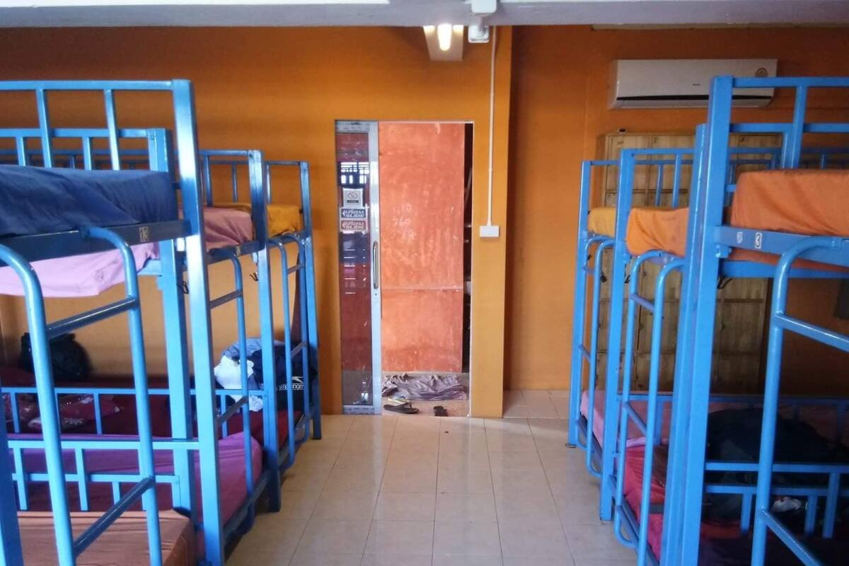A dormitory room with bunk beds arranged in two rows.