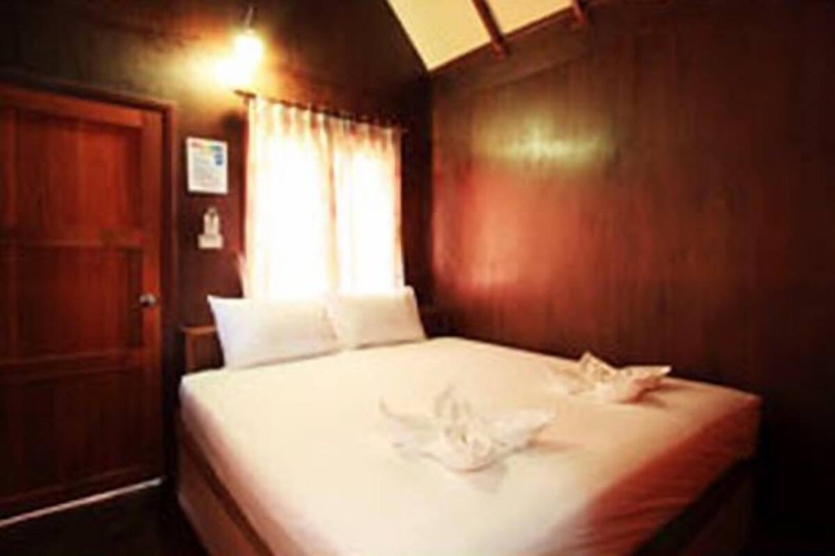 A neatly made bed with white linens and a folded towel on the bed.