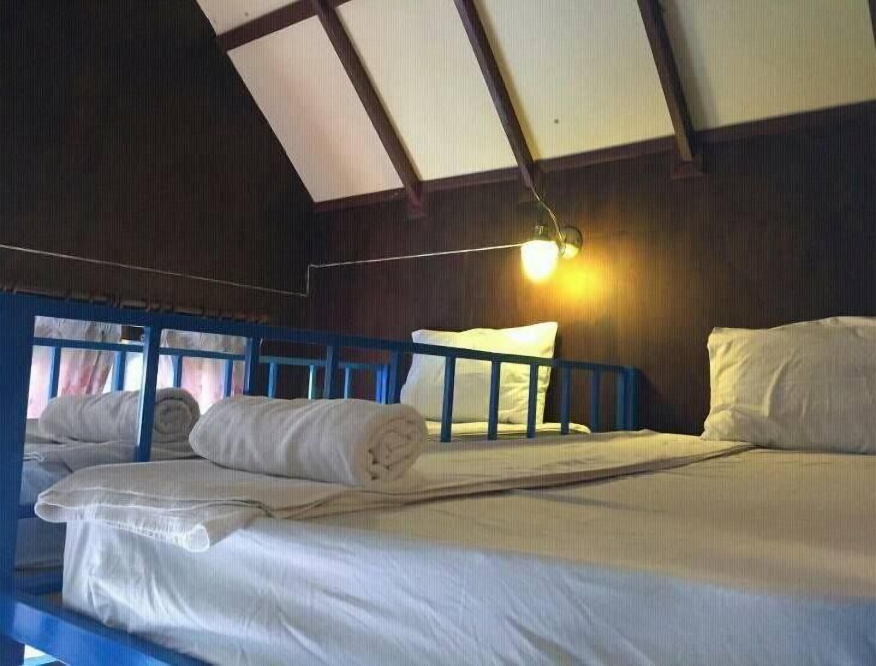 Ein Schlafraum mit Stockbetten, einem Schreibtisch und einem Einzelbett.