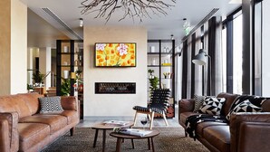 A modern living room with leather sofas, a coffee table, and a bookshelf. - Mercure Bendigo Schaller (Bendigo)