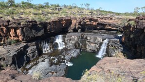A natural rock formation with a waterfall and a pool. - Mitchell Falls Wilderness Lodge (Mitchell Plateau)