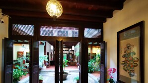 An open doorway leading to a courtyard with potted plants and a tiled floor. - East Indies Mansion (George Town)