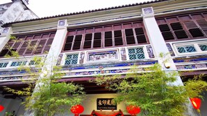 A traditional East Indies Mansion with ornate decorations, a wooden door, and red lanterns. - East Indies Mansion (George Town)