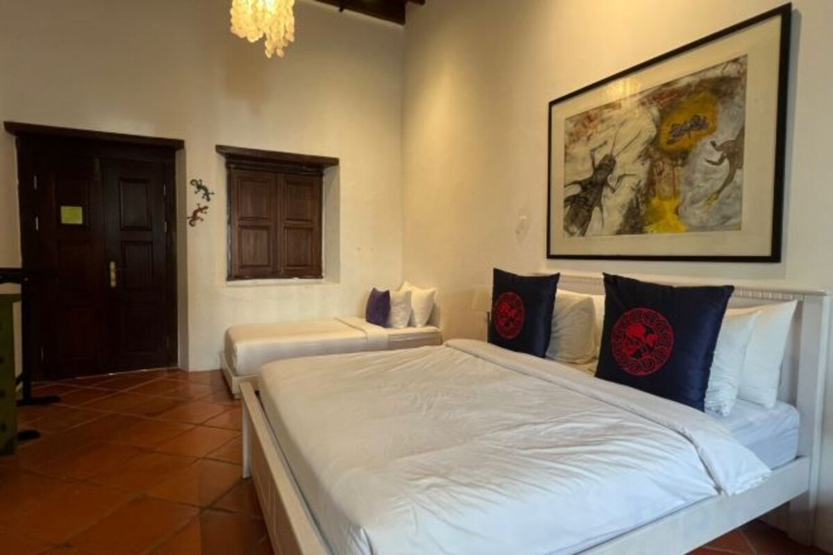 A bedroom with a large bed, a window, and a door.