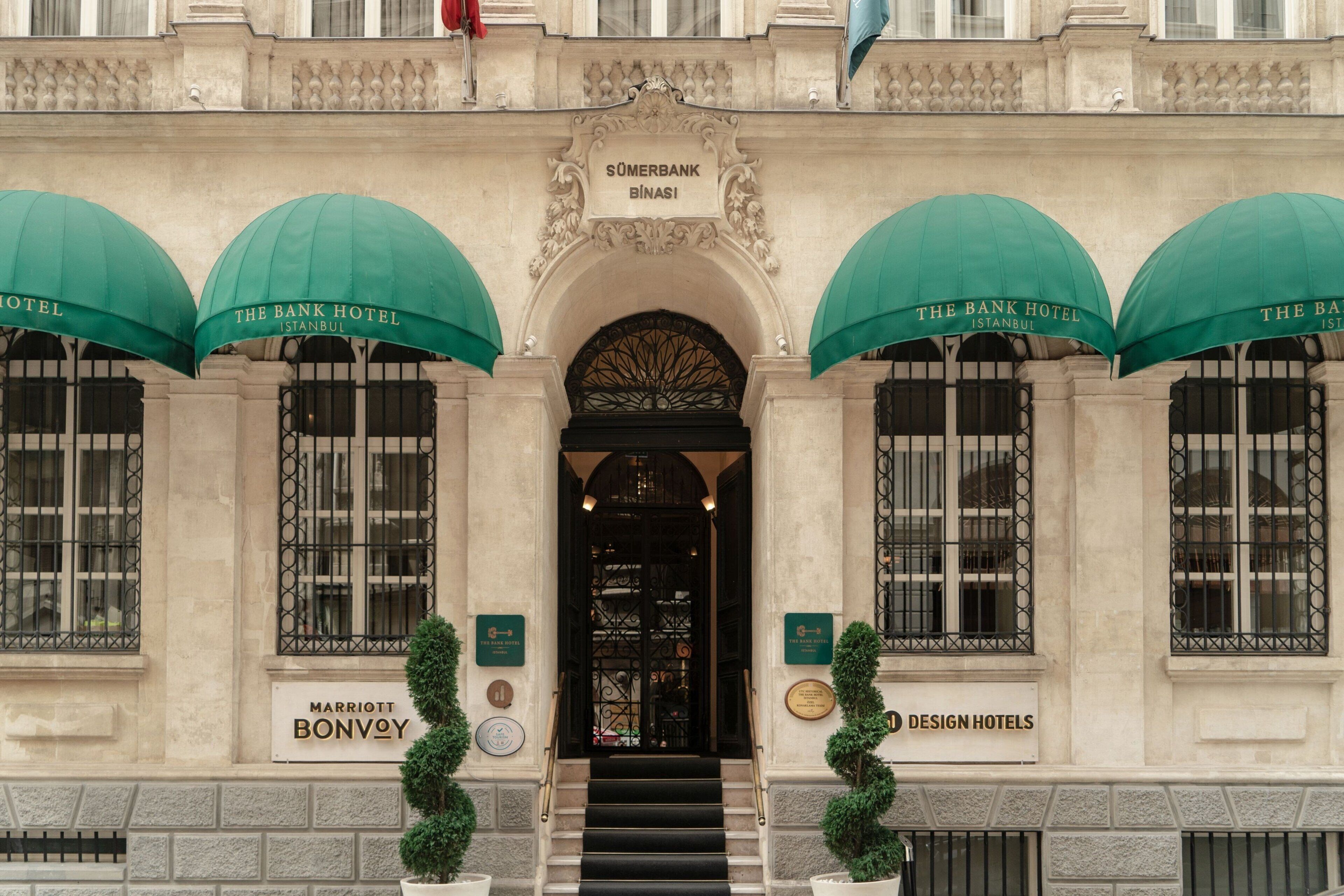 Ein historisches Gebäude mit einem imposanten Eingang, mit dem Bank Hotel und einem Schild für die Sumerbank Binasi.