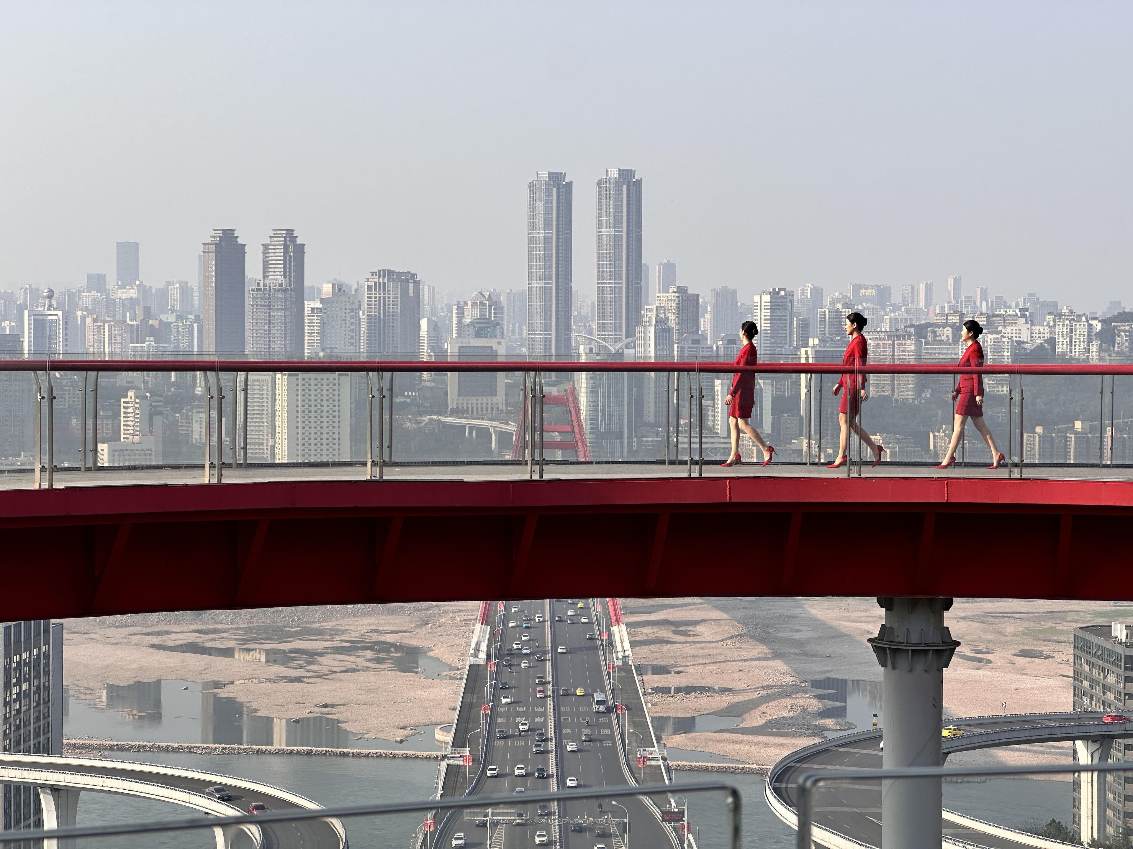 Un puente peatonal con un paisaje urbano al fondo.