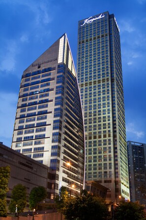 Deux immeubles de grande hauteur aux façades vitrées réfléchissantes, avec un ciel dégagé.