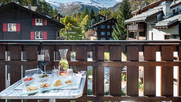 A chalet with a wooden balcony overlooking a mountain. - Jolimont Apartments (Zermatt)