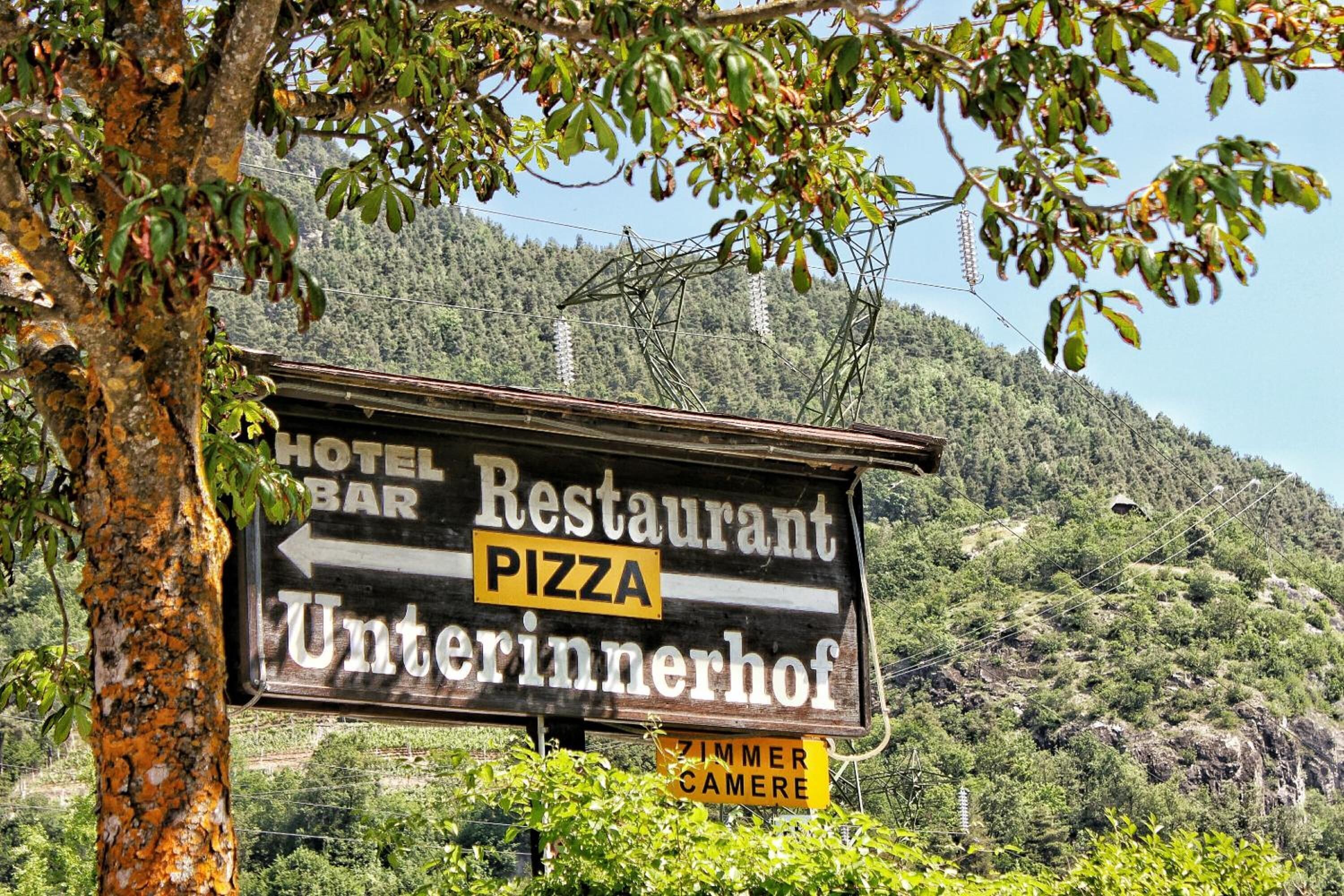 Une enseigne pour un restaurant et un bar, avec une montagne en arrière-plan.