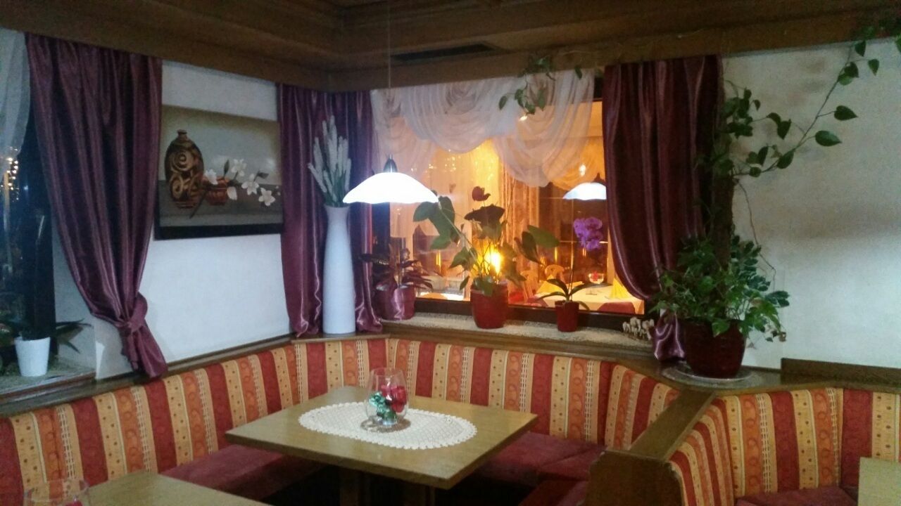 Un coin salon confortable avec une table, des bancs rembourrés et des plantes en pot.