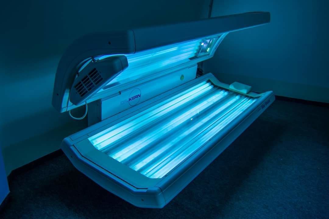 Un appareil de luminothérapie aux ultraviolets doté d’un panneau de commande et d’un repose-pieds.