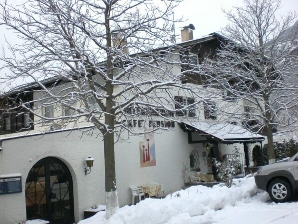 A building with a sign that reads "CAFE" and a car parked in front. - Hotel Unterinnerhof (Renon)