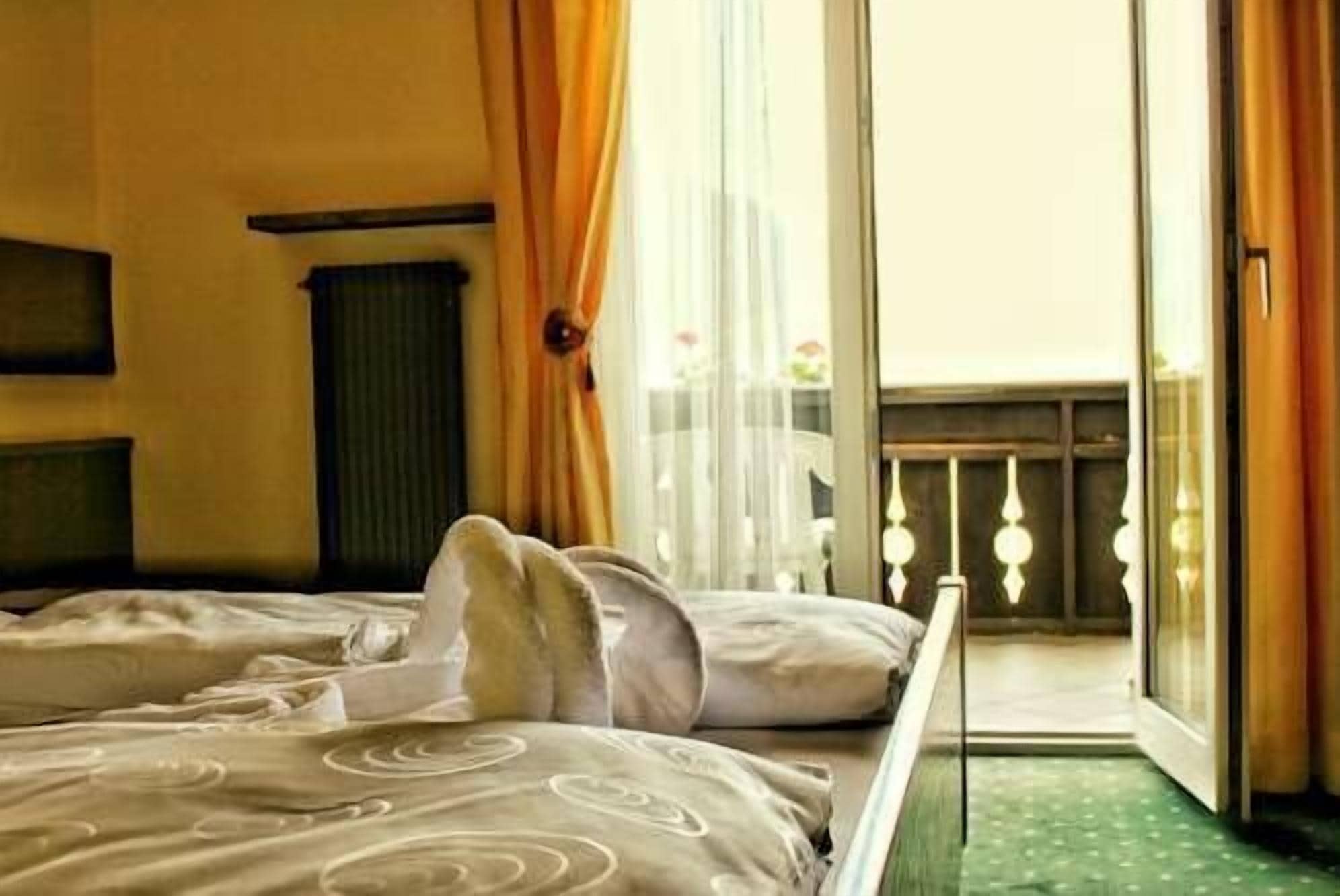 Une chambre d’hôtel avec un lit, un radiateur et une vue sur le balcon extérieur.