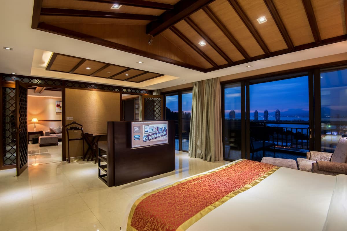 Une chambre d’hôtel avec un grand lit, un bureau et une vue sur le paysage urbain.