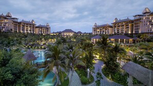 A resort with multiple buildings, a swimming pool, and lush greenery. - Raffles Hainan (Lingshui)