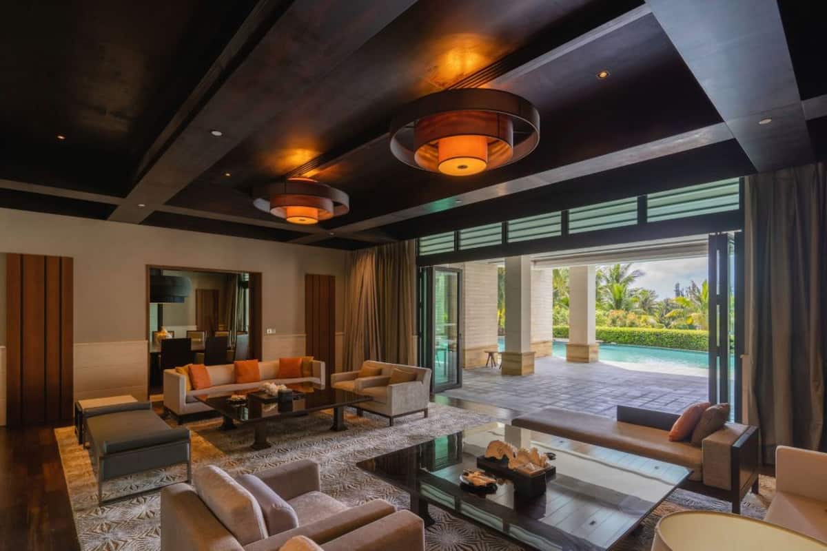 A modern living room with a large window, a sofa set, a coffee table, and a fireplace.