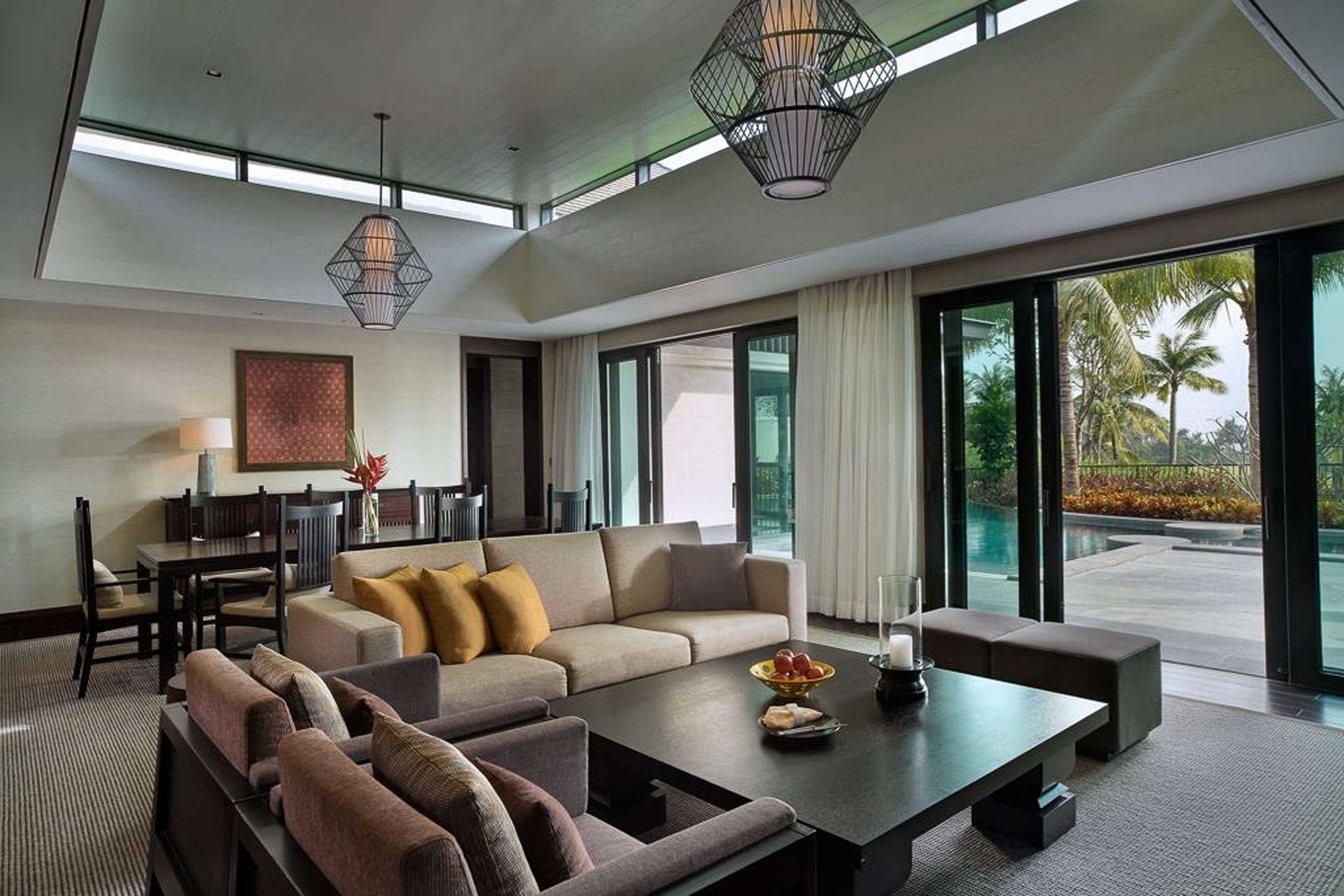 A modern living room with a sofa, coffee table, and dining area.
