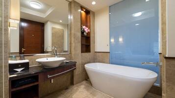 Un bany modern amb una banyera autònoma, un lavabo doble i un mirall gran.