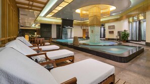Un área de spa con sillones reclinables, bañera de hidromasaje y una fuente decorativa.