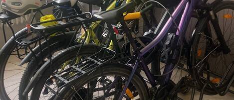 Des vélos sont garés dans une pièce qui contient un radiateur et une fenêtre.