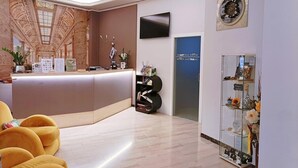 A modern reception area with a counter, seating, and a display of amenities. - Smart Hotel Bartolini (Montecatini Terme)