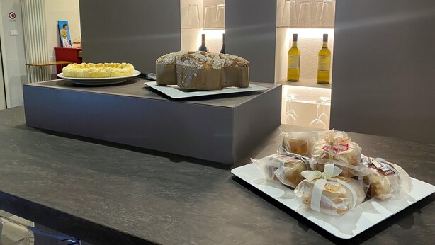 A counter with a cake, bread, and bottles of liquor. - Smart Hotel Bartolini (Montecatini Terme)