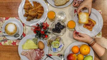 A table with various food items, plates, and a small Christmas decoration.