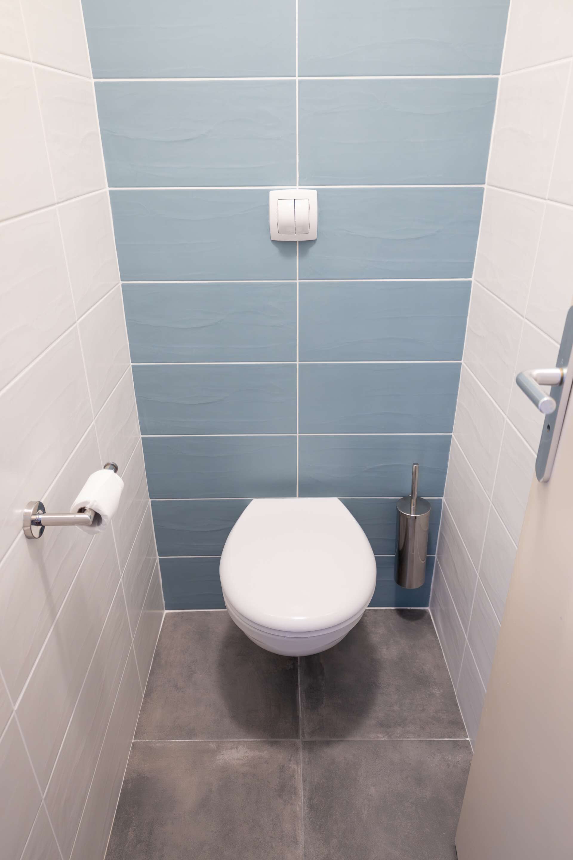 A small bathroom with a toilet, a toilet paper holder, and a trash can.
