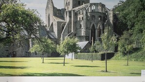 Quarto com vista para uma igreja histórica e um jardim bem cuidado.