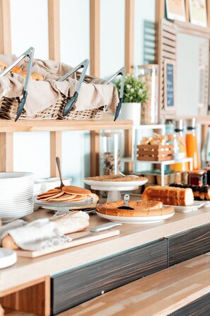 A breakfast buffet with various food items and serving utensils. - Brit Hotel Confort Saint-Lô (Saint-Lo)