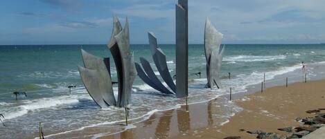 A beach with abstract sculptures and a clear view of the ocean.