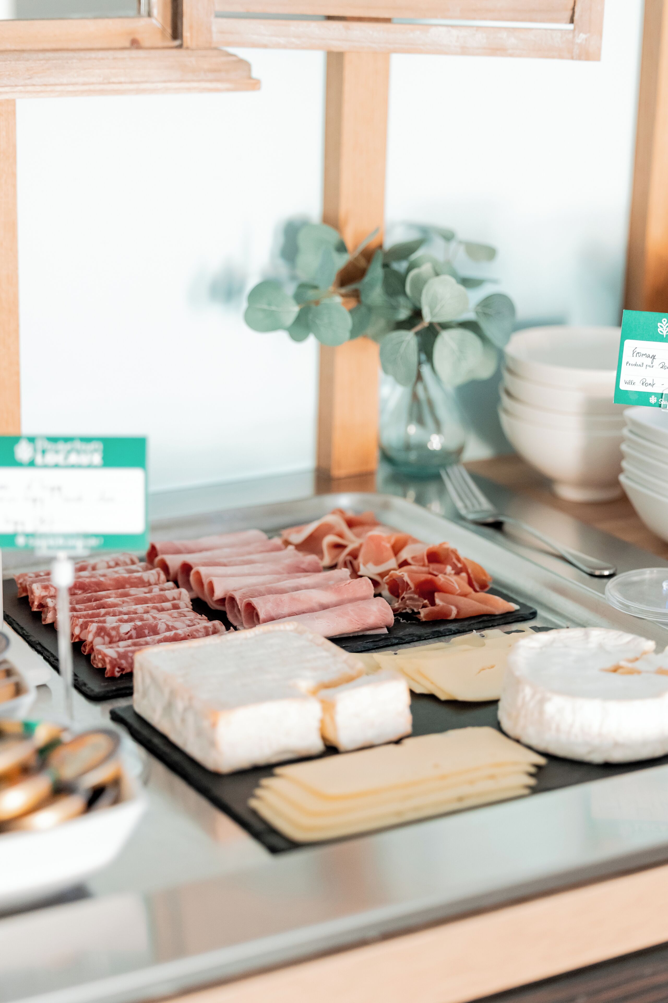 A buffet with various meats and cheeses.