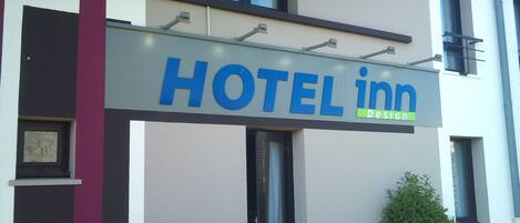 A hotel sign with the name 'HOTEL inn' and a 'DESIGN' label.