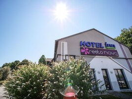 Un bâtiment sur lequel on peut lire l’inscription suivante : « HÔTEL INN, restaurant Novo ».
