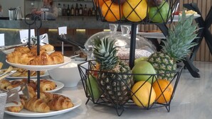 Un bufé con una variedad de frutas y pasteles.