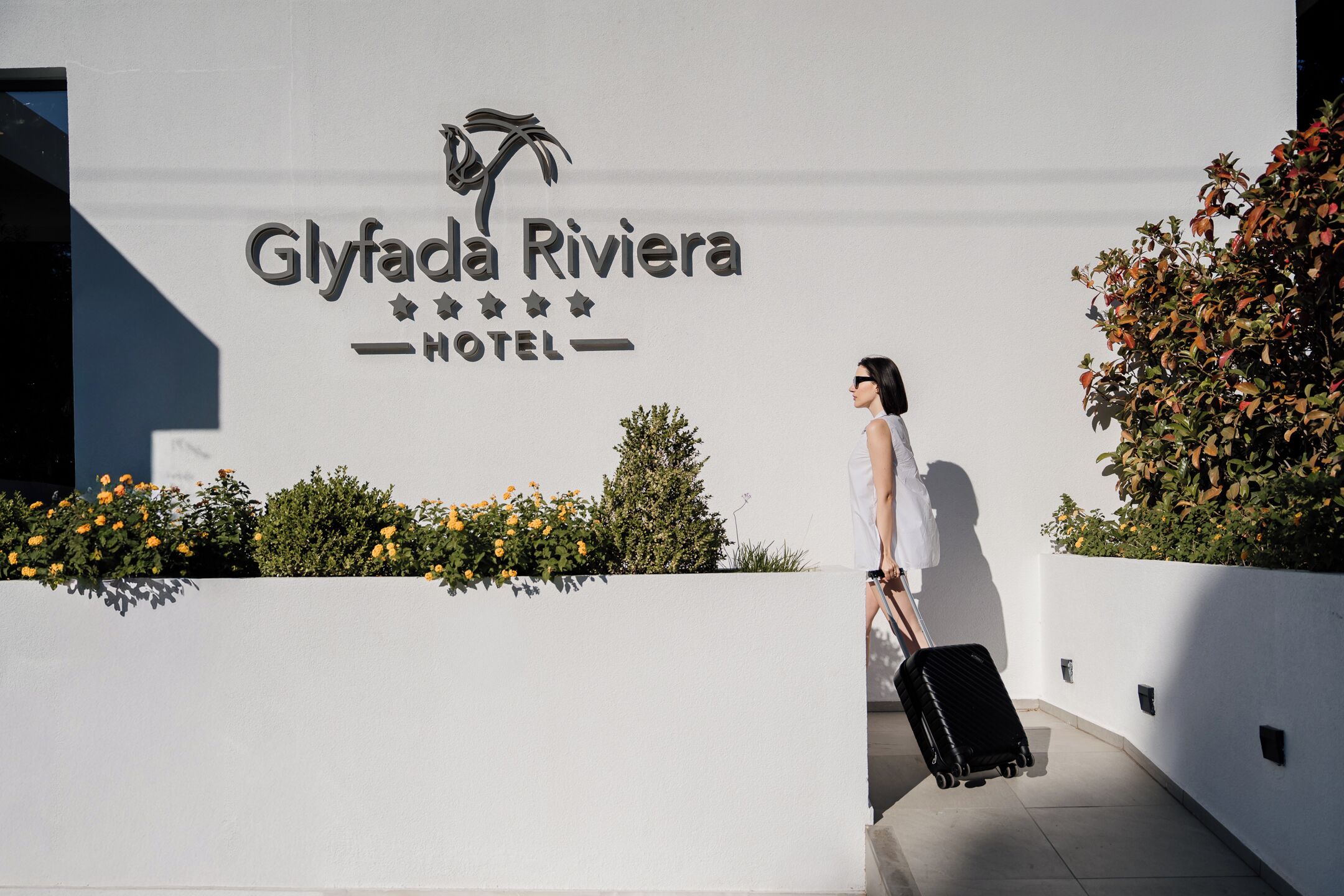 A sign for the Glyfada Riviera Hotel with a logo featuring a horse and rider.