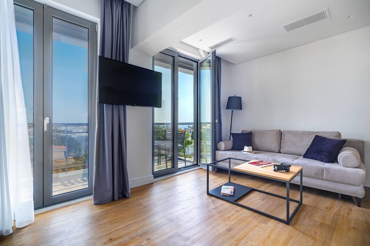 A modern living room with a sofa, a coffee table, and a flat-screen TV.