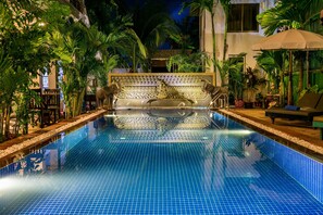 A pool with tiled flooring, surrounded by palm trees and a decorative bench. - Asanak D'Angkor Boutique Hotel (Siem Reap)
