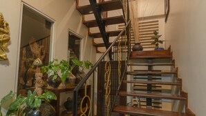 A staircase with a checkered floor pattern, wooden steps, and a metal railing.