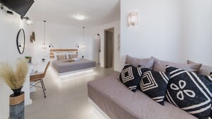 Un dormitorio moderno con una cama, un sofá, un escritorio y un televisor montado en la pared.