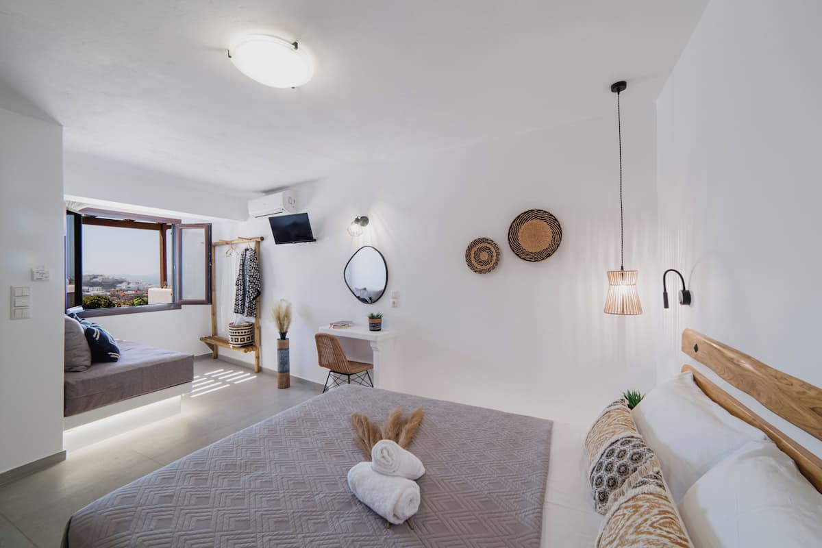 Un dormitorio moderno con una cama grande, un escritorio y vistas a la ciudad.