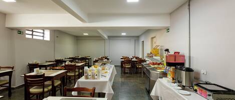A spacious dining area with multiple tables and chairs, equipped with various food service appliances and supplies.