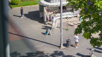 A street scene with a kiosk selling newspapers and magazines.