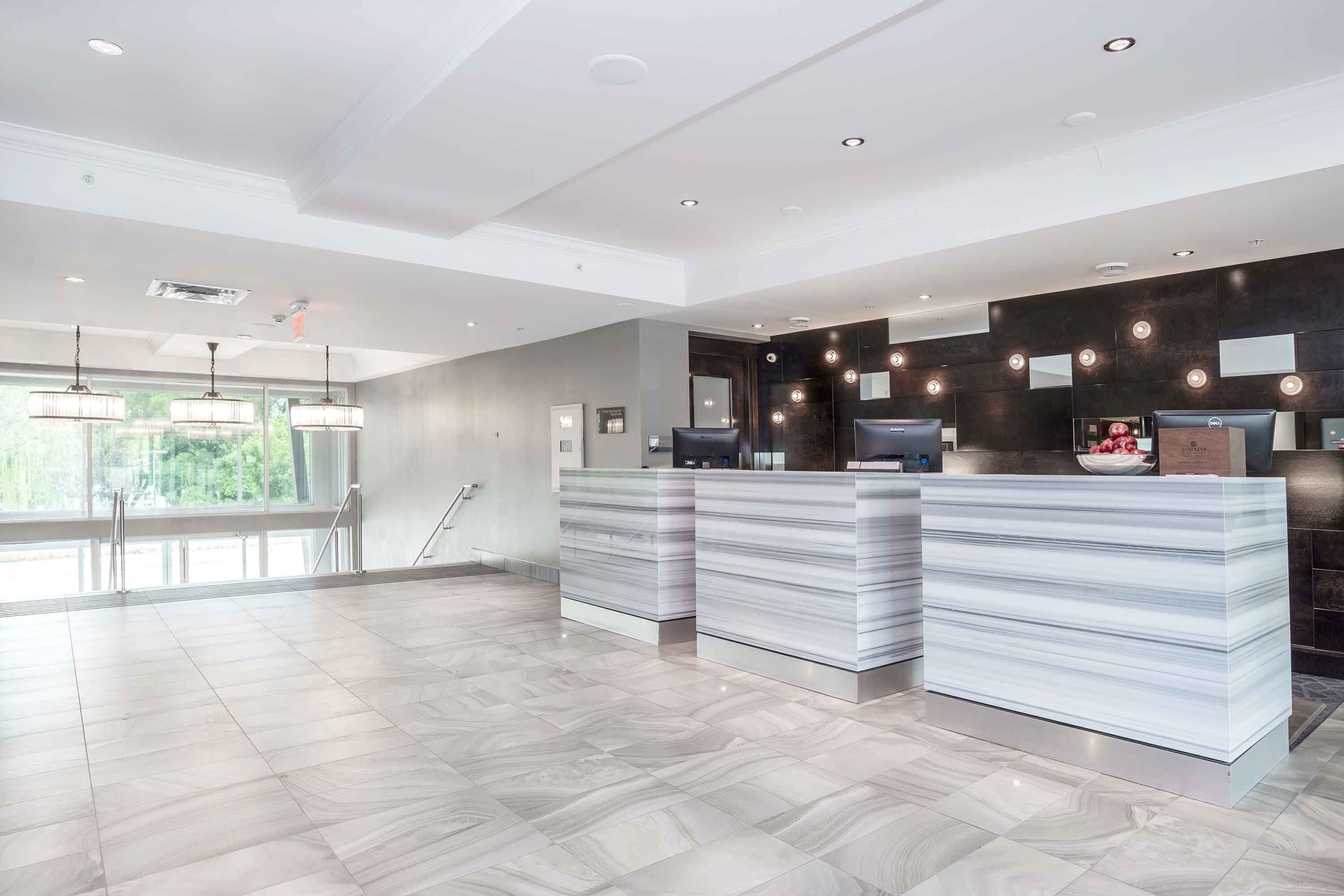 A modern reception area with marble counters, large windows, and a spacious layout.