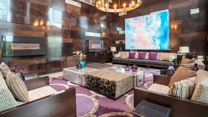 A modern living room with a fireplace, a large abstract painting, and a cozy seating area with patterned cushions. - Sandman Signature Kamloops Hotel (Kamloops)
