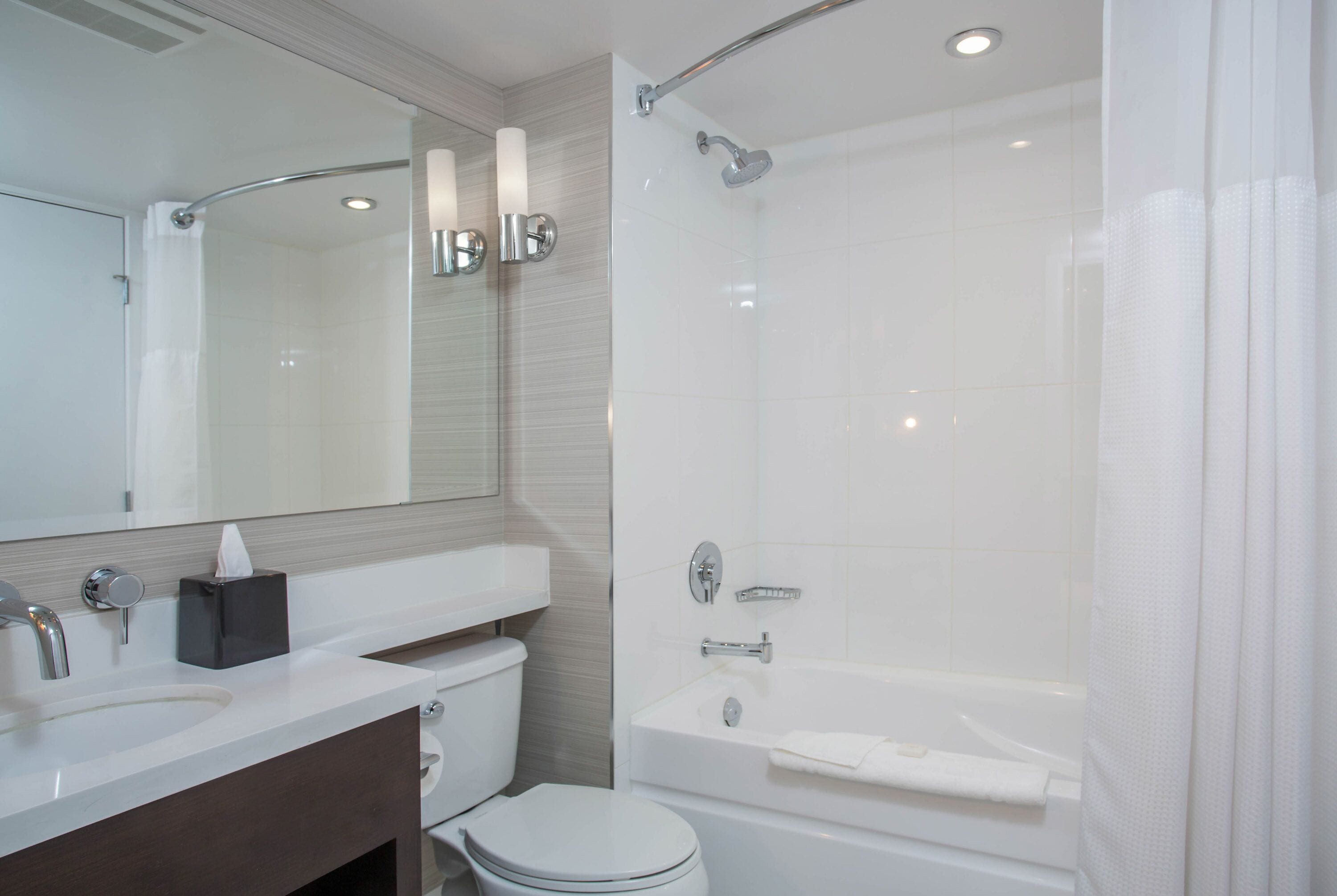 A modern bathroom with a white sink, toilet, and bathtub.