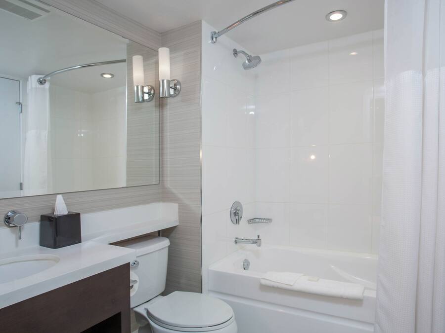 A modern bathroom with a white sink, toilet, and bathtub.