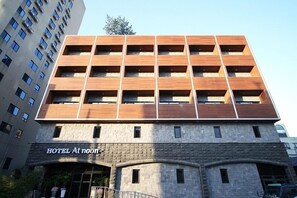 Ein Hotel mit modernem Design, das sich durch ein flaches Dach und eine Fassade aus Stein auszeichnet.