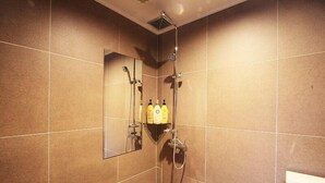 A shower area with a mirror, a handheld showerhead, and two bottles of shampoo. - Hotel At noon (Jeju City)